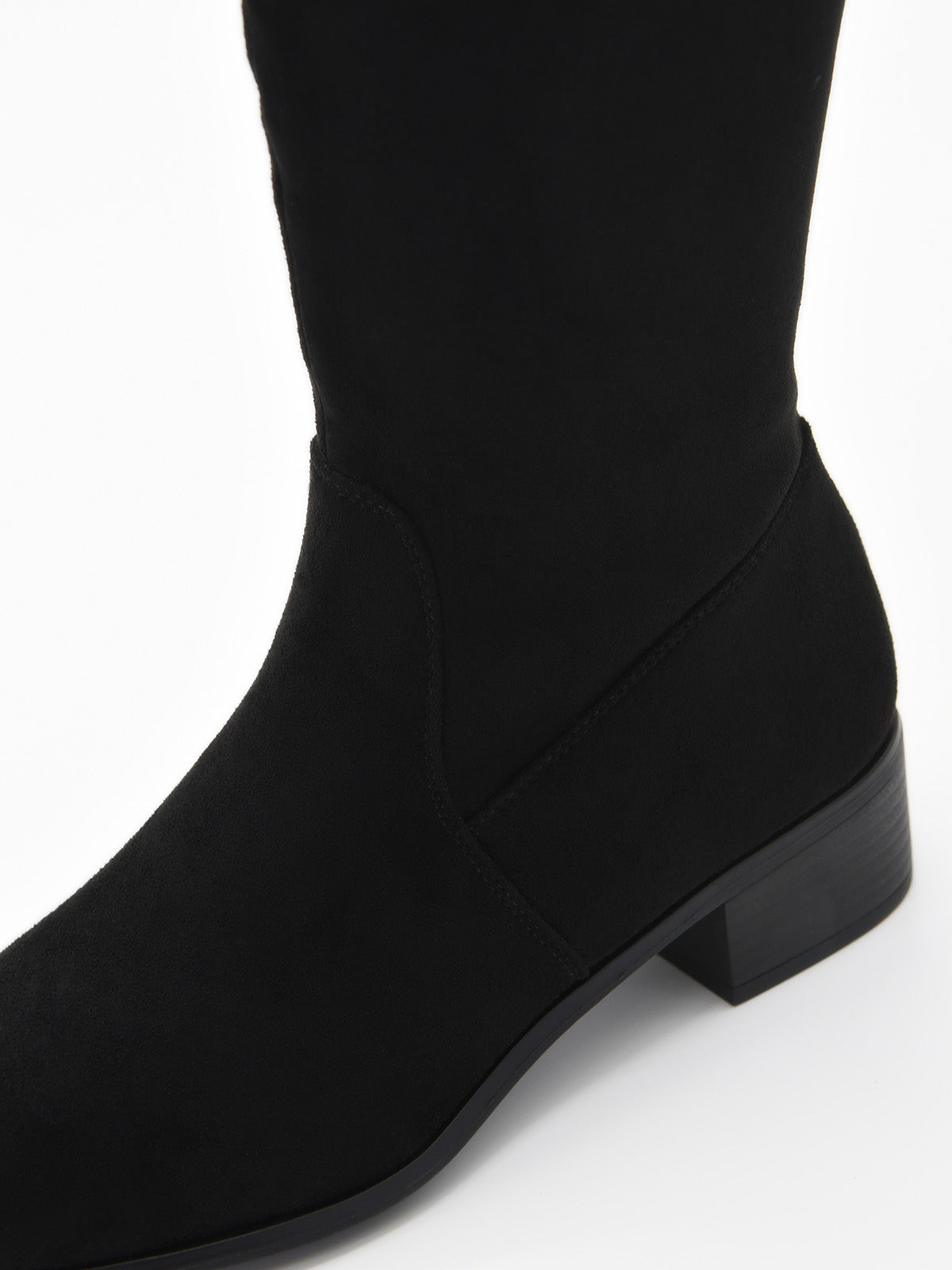 Bota alta de serraje negro con caña lisa, punta fina y tacón bajo cuadrado.