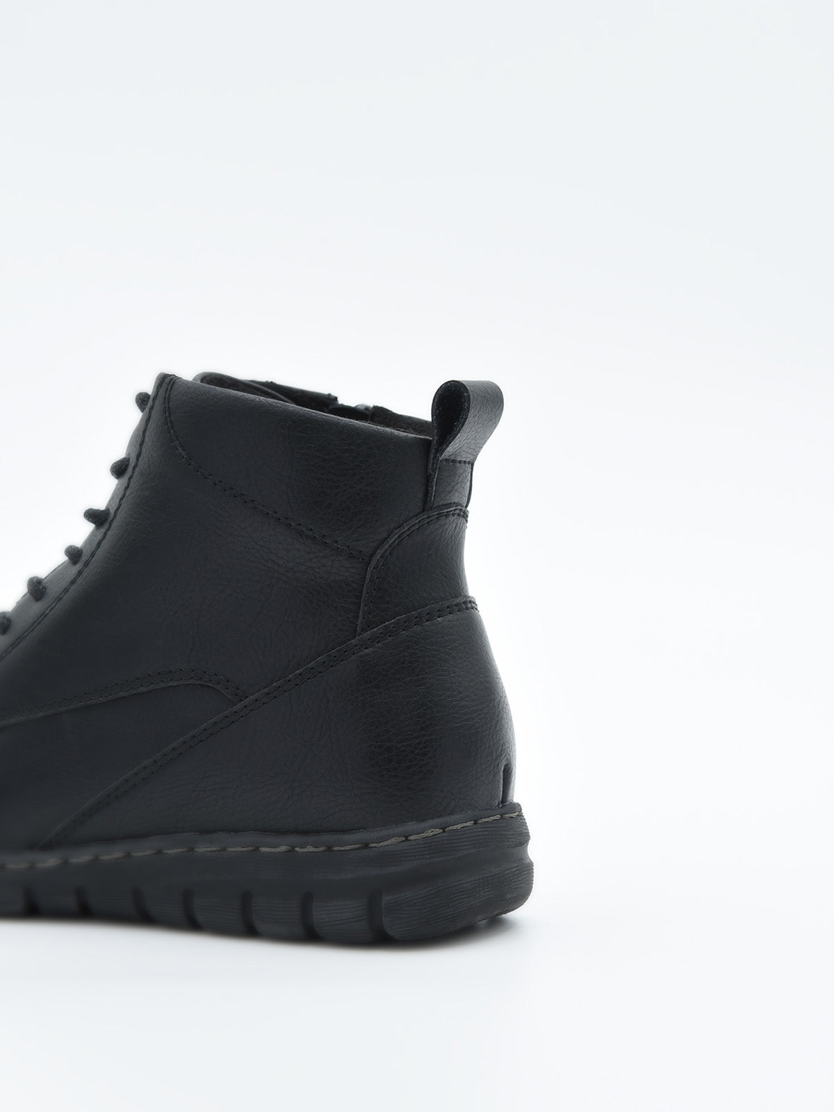 Botín negro de piel estilo combat con cordones, cremallera lateral y suela robusta de tacón bajo cuadrado.