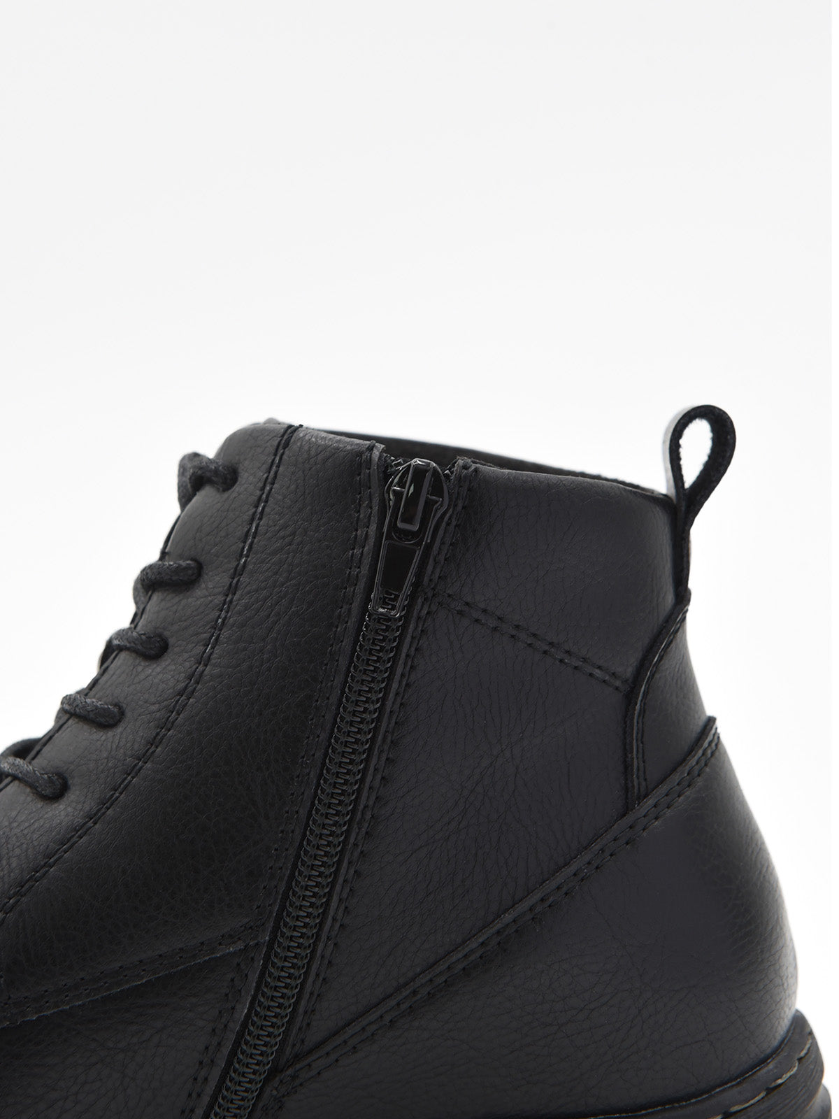 Botín negro de piel estilo combat con cordones, cremallera lateral y suela robusta de tacón bajo cuadrado.