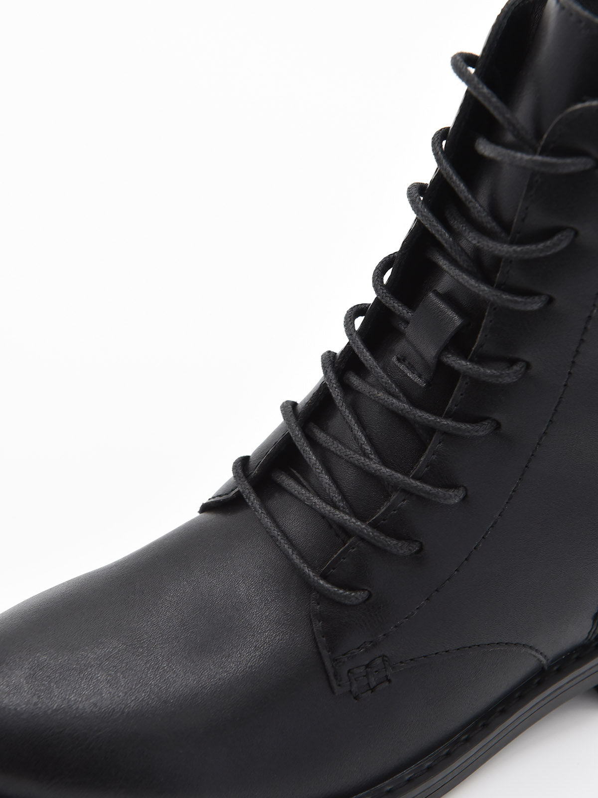 Botín negro de piel con cordones, cremallera lateral y suela robusta de tacón bajo cuadrado.
