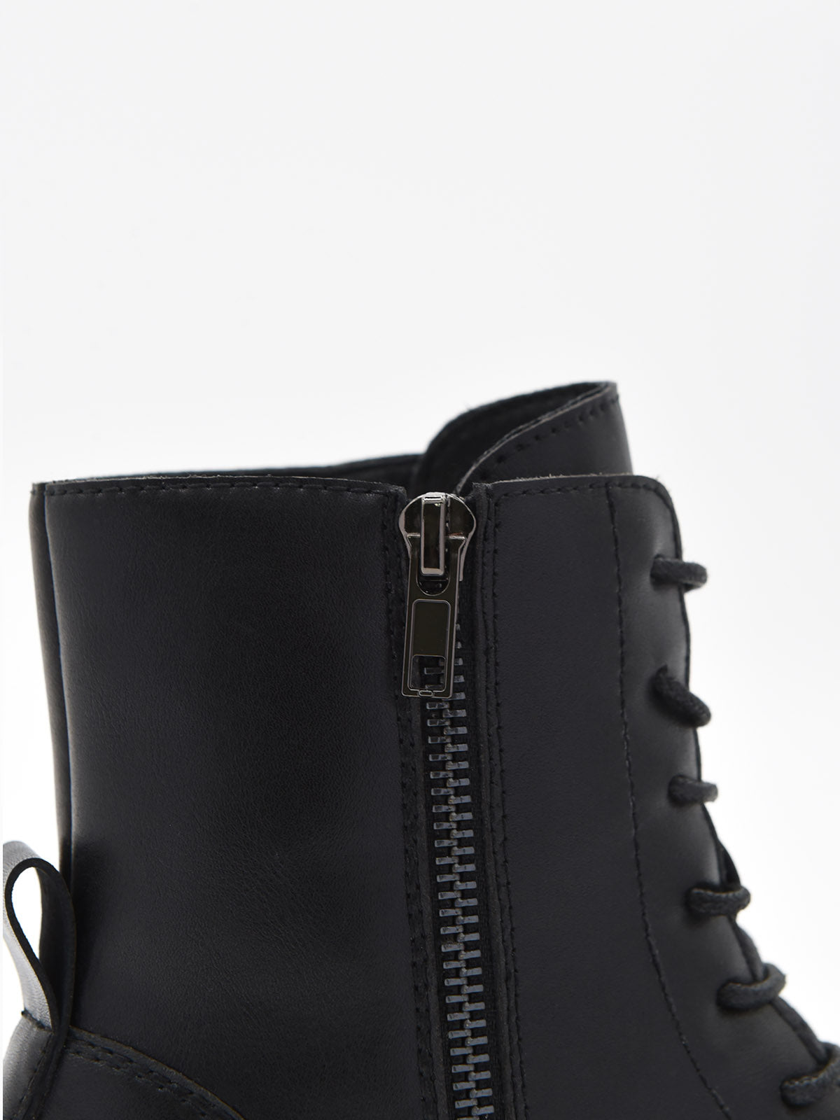 Botín negro de piel con cordones, cremallera lateral y suela robusta de tacón bajo cuadrado.