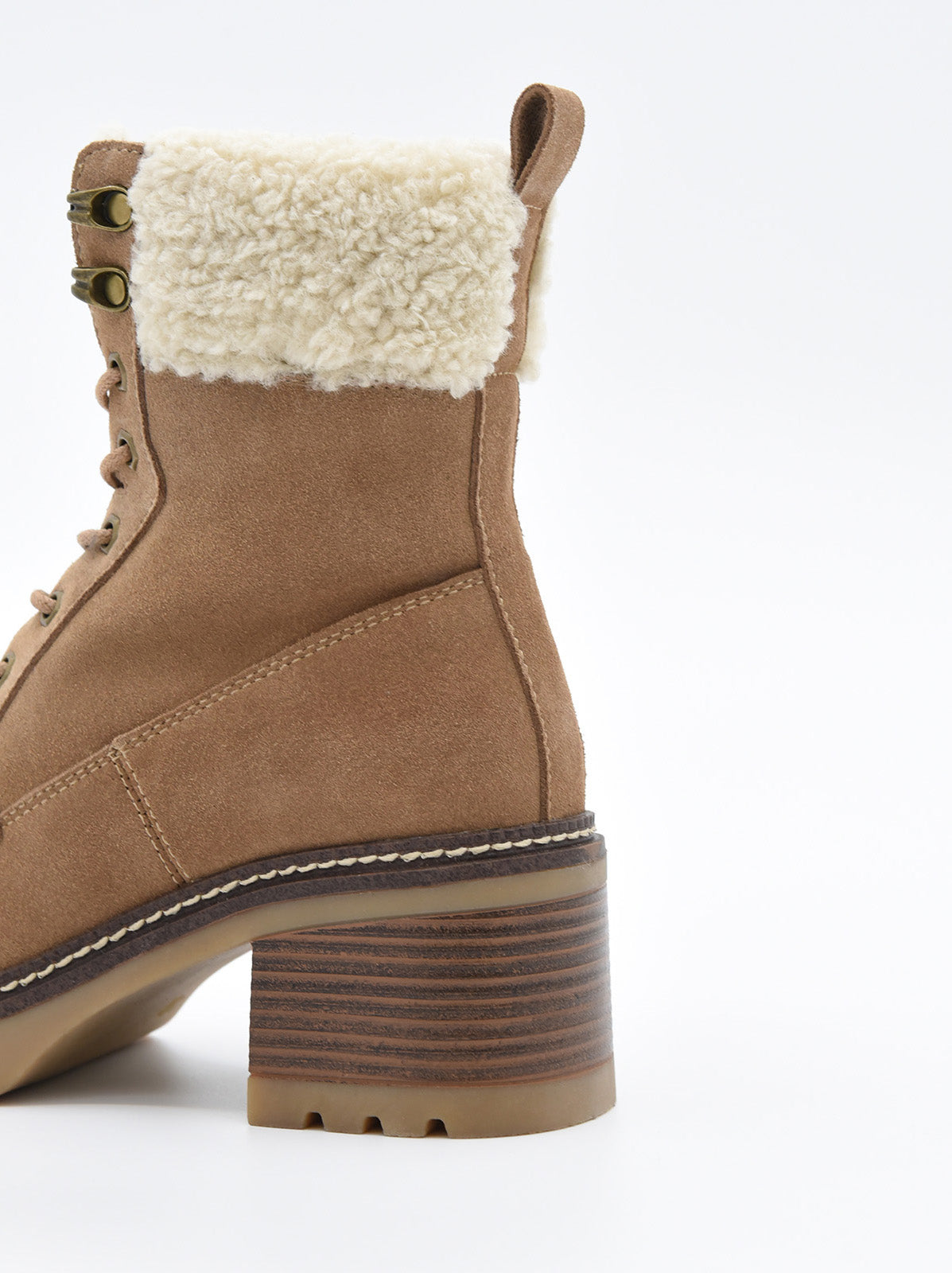 Bota mocha de serraje con cordones, forro de borreguito en la caña y tacón ancho con suela dentada.
