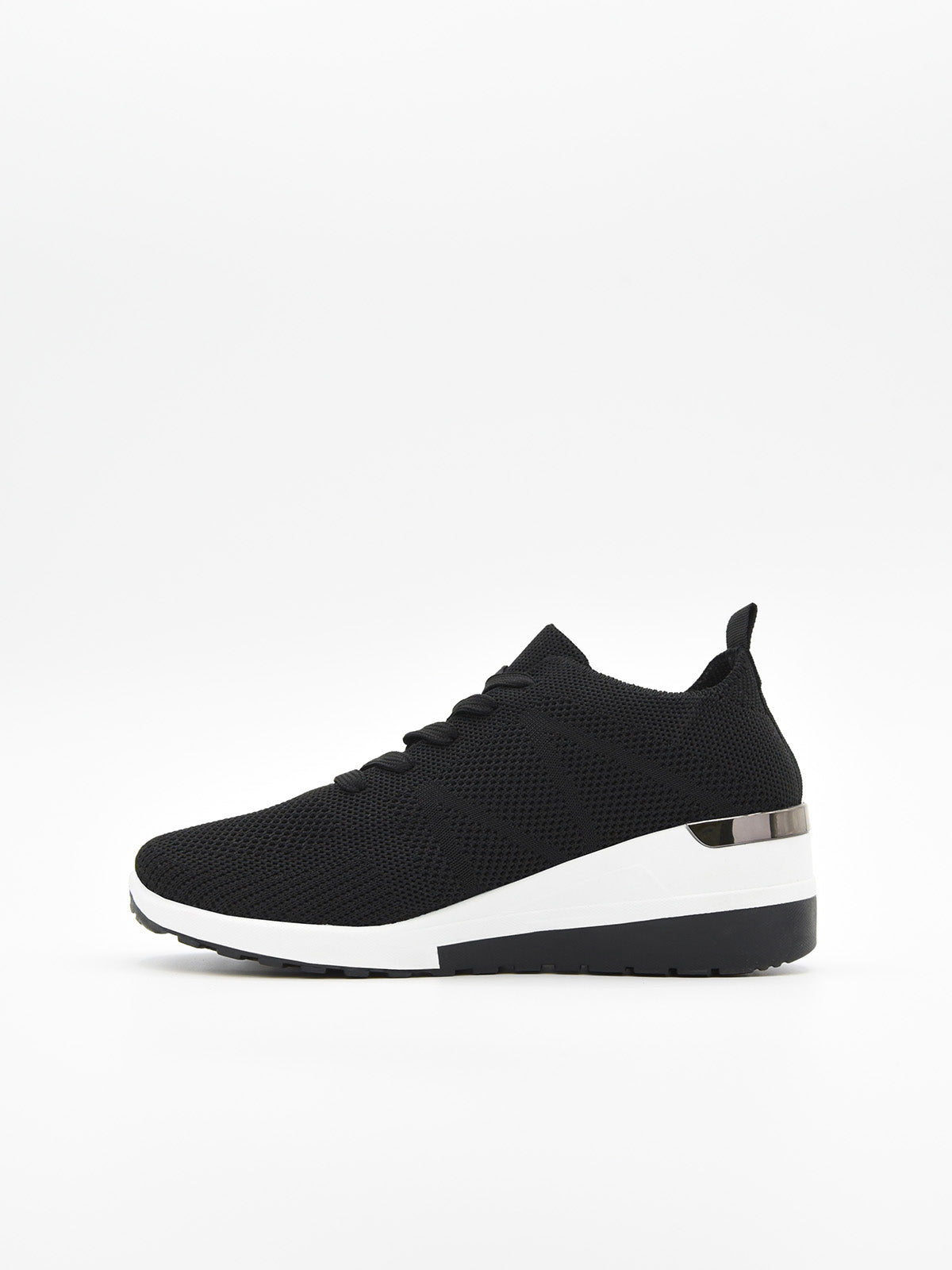 Zapatilla negra de tejido transpirable, con agujetas, plataforma bicolor blanca y negra, y detalle metálico en el talón.