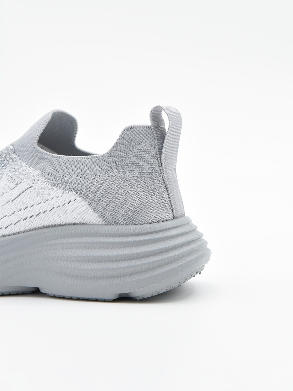 Zapatilla slip-on de punto knit en degradado gris con suela chunky ondulada gris y logo Nyrex en relieve.