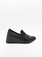 Zapato casual negro para mujer, estilo slip-on con elástico superior y plataforma ergonómica continua.