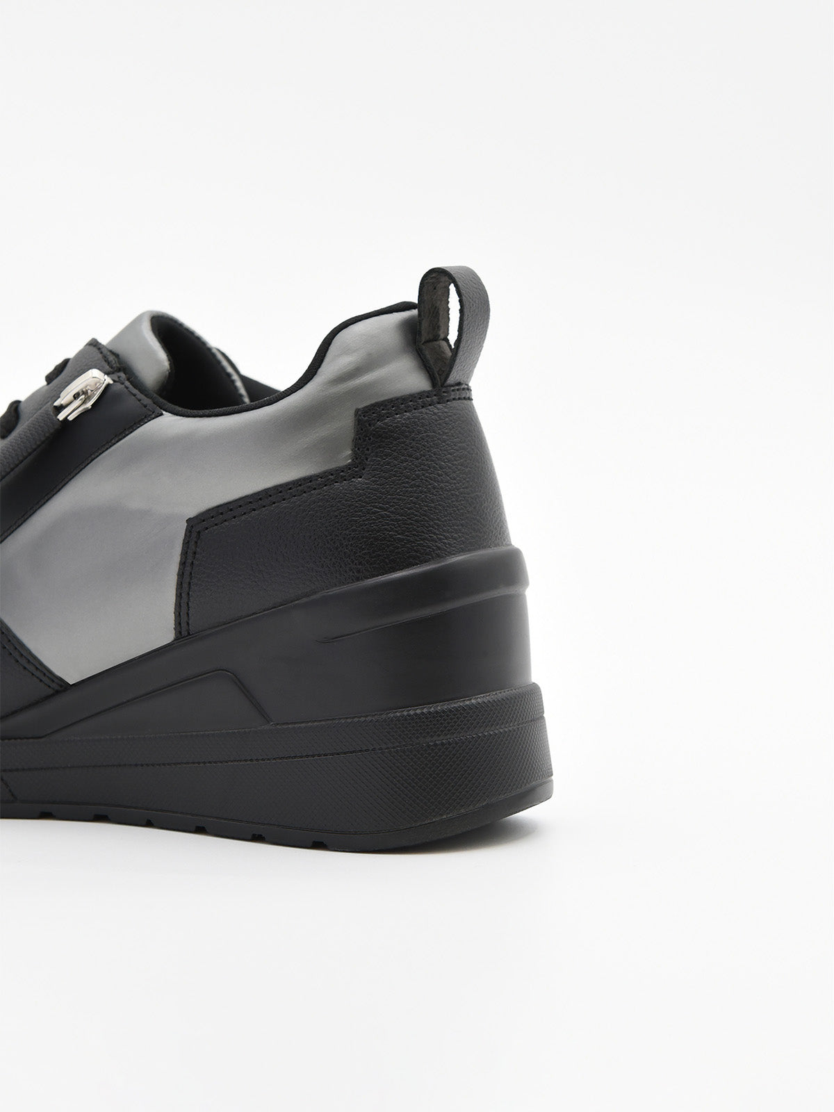 Zapatillas casual negras para mujer con plataforma ergonómica, agujetas y detalles metálicos decorativos en el lateral.