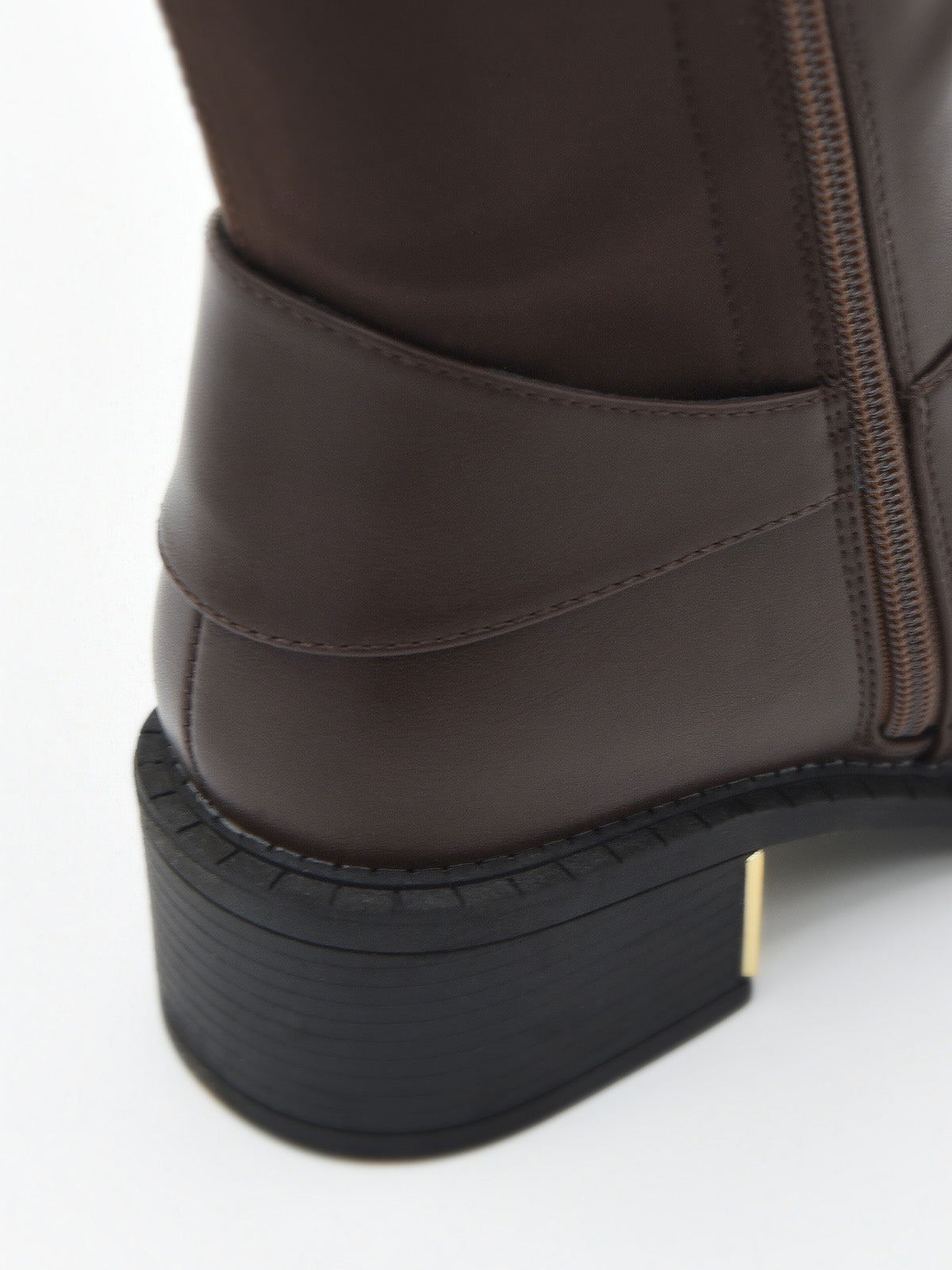Bota alta marrón con hebilla dorada lateral y tacón bajo cuadrado con detalle metálico.