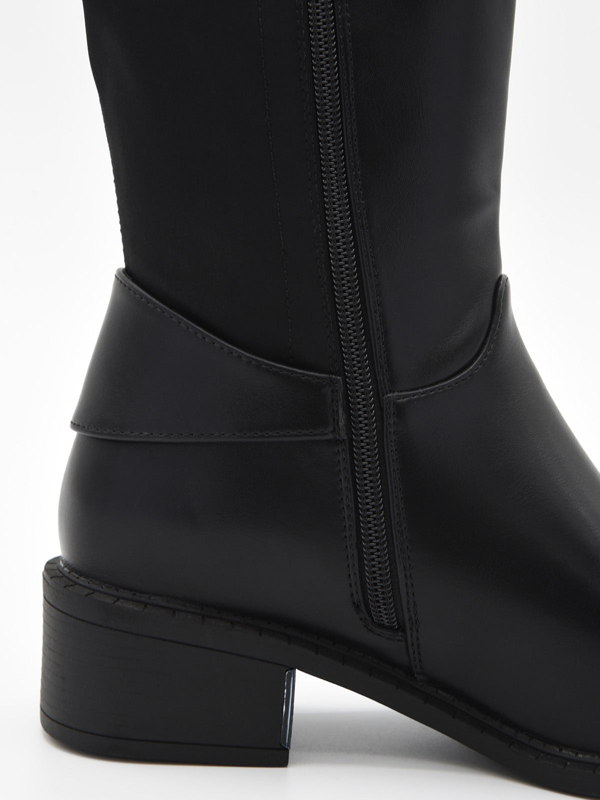 Bota alta negra de caña lisa con hebilla lateral metálica y tacón bajo cuadrado.
