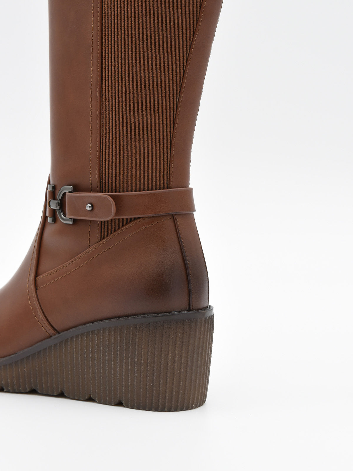 Bota alta camel con cuña media, hebilla lateral metálica y parte trasera elástica.